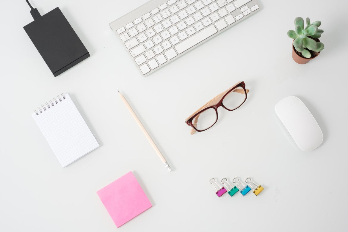 Desk with a keyboard, office supplies and plant