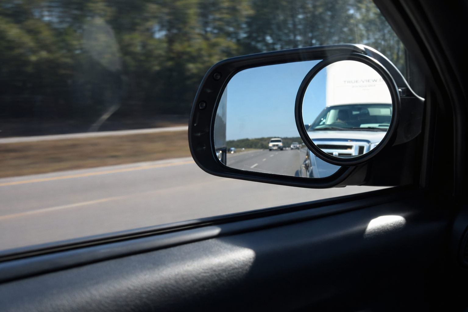 True View® Accurate Imaging Blind Spot Mirror (for trucks/SUVs/RVs) Car side mirror reflecting a truck on a road with trees in the background